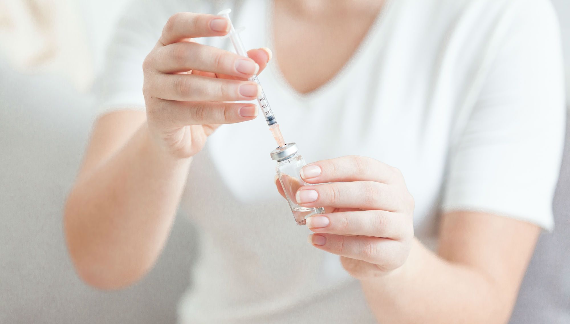 A woman prepares a vaccine.