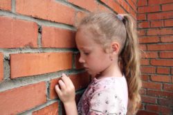 sad child at wall