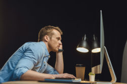 A man gets tired working at a computer.