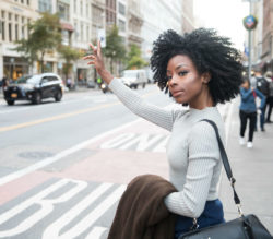 A woman hails a rideshare.