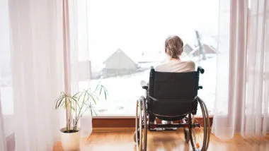 canadian woman looking out the window at the snow trapped in room with bedbugs