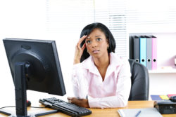 A woman in an office looks worried.