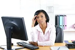 A woman in an office looks worried.