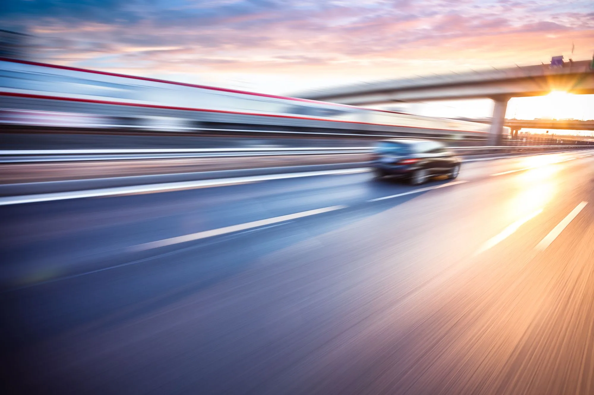 toyota speeding down freeway at sunset