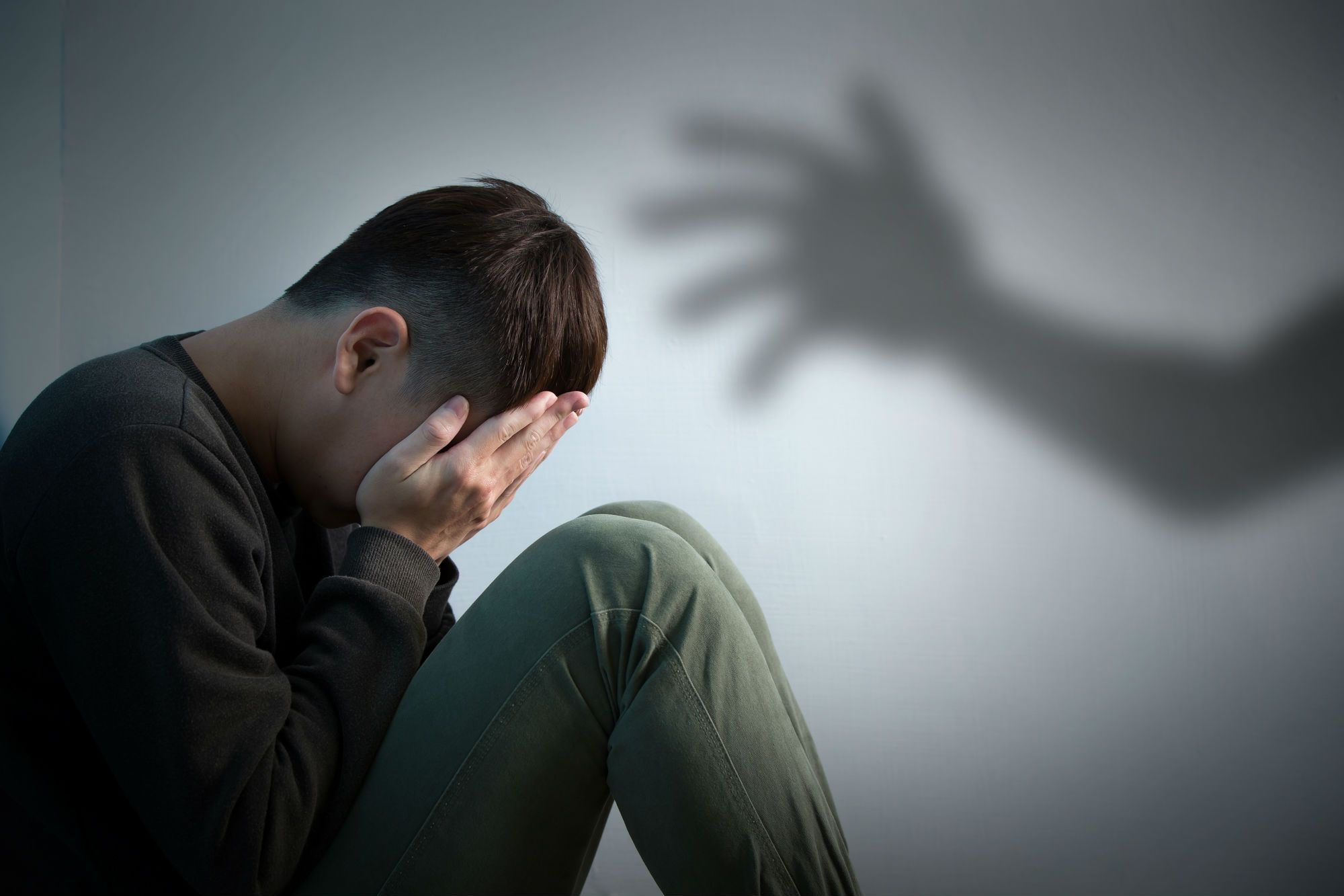 Depressed man sitting on floor
