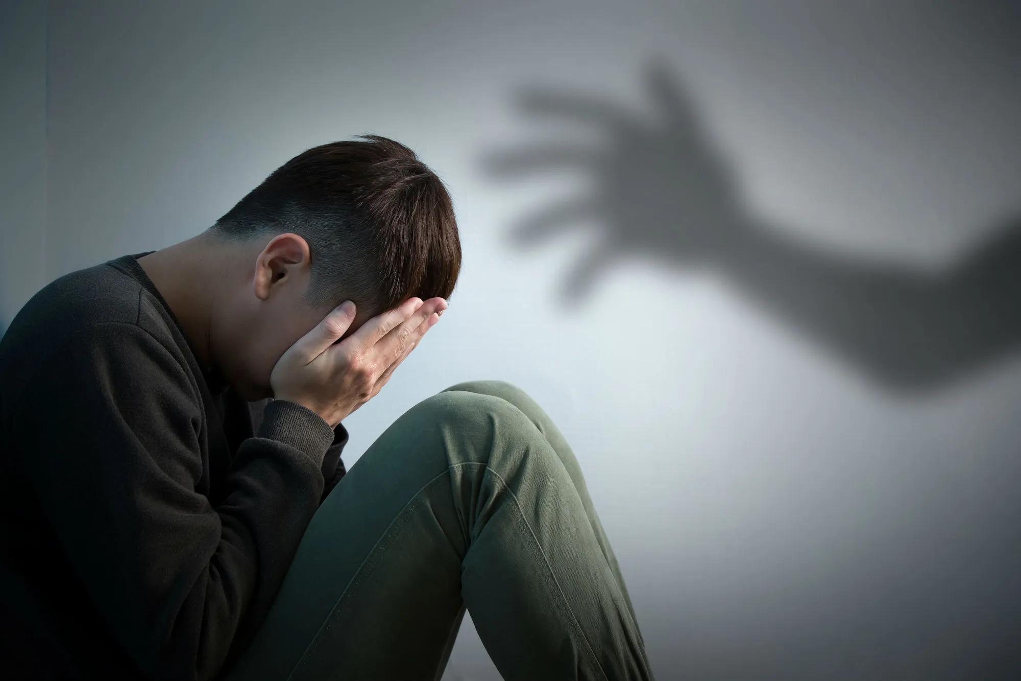 Depressed man sitting on floor