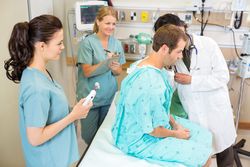 doctor listening to client lungs in hospital