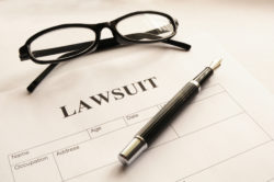 Pen, glasses, lawsuit form