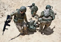 Soldiers rescuing a fellow servicemember in combat.