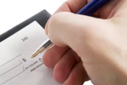 Person writing check regarding global learning group charitable donation tax scheme