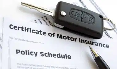 Car key on car insurance papers