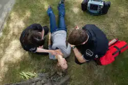 EMTs work on an unconscious patient.