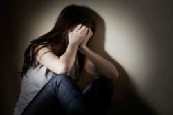 A girl covers her face with her hands.