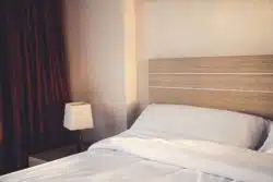 Hotel room bed, lamp, and curtain