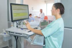 A nurse works at a computer.