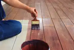 man painting wood floor