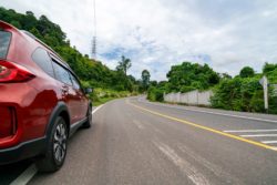 red acura suv driving down road