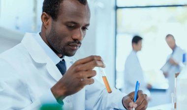 A scientists studies a test tube.