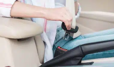 woman buckling seat belt in car