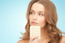 woman holding birth control pills