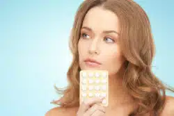 woman holding birth control pills