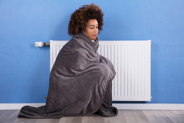 woman sitting near heating in gateway plaza apartment