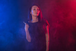 Young woman vaping e-cigarette