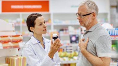 pharmacist helping male patient with medication