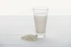 Glass of milk with rice next to it