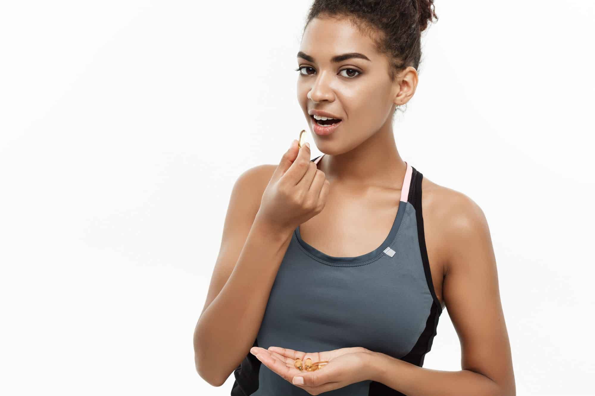 Athletic woman takes a dietary supplement