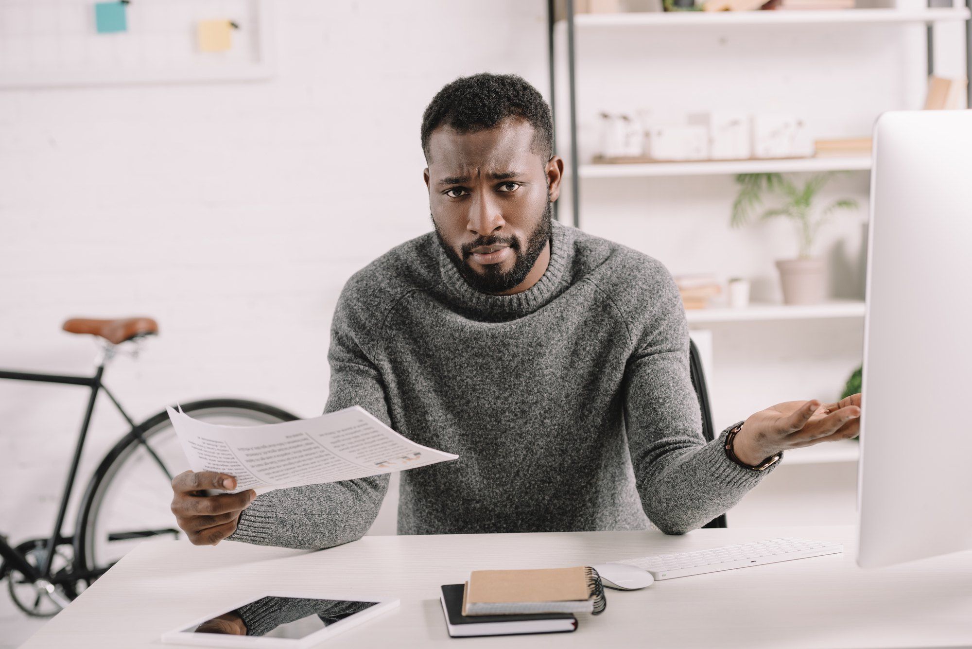 confused african american man dealing with insurance paperwork