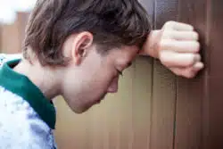 Teen looking upset and defeated regarding former students of Grenville Christian College class action lawsuit