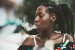Young woman exhales vape cloud