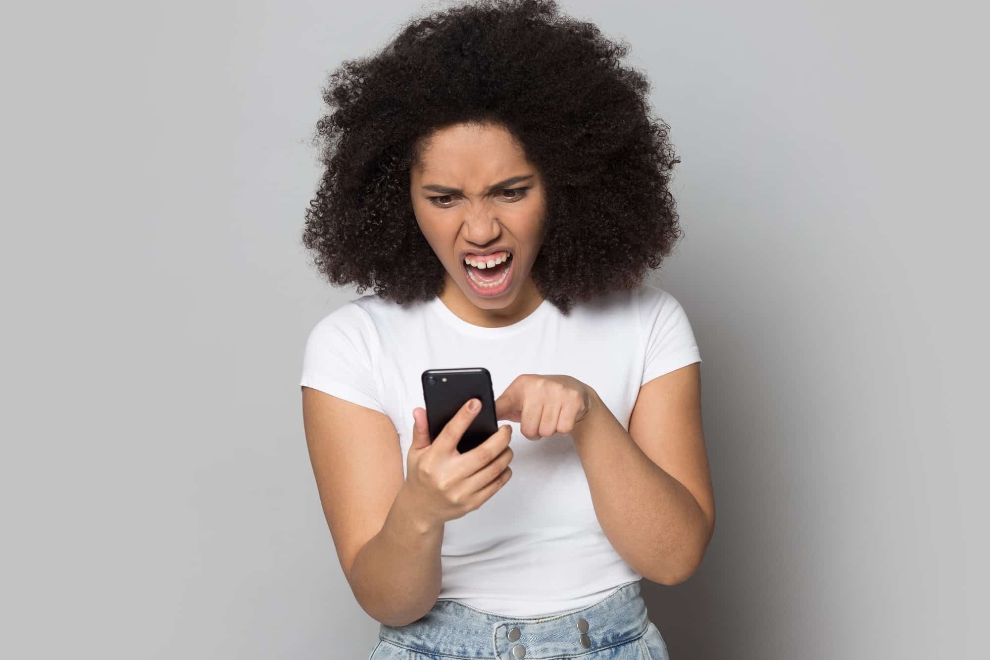 frustrated african american girl dealing with text spam