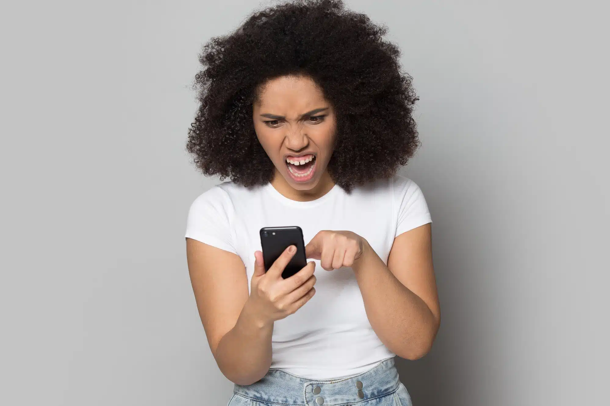 frustrated african american girl dealing with text spam