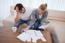 stressed couple looking at bank statements
