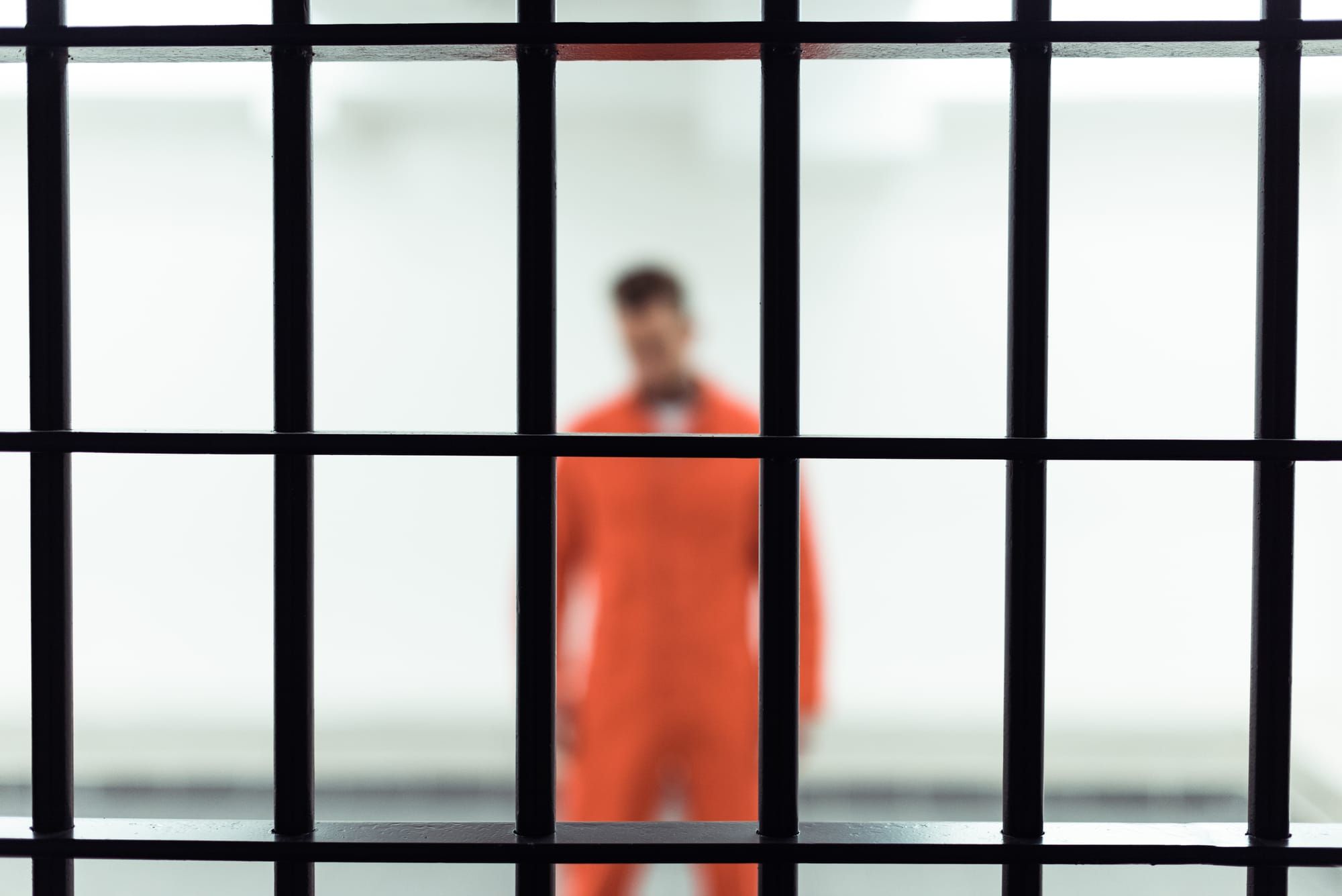 inmate standing behind bars regarding visitations being suspended at jails and prisons across Canada over the coronavirus