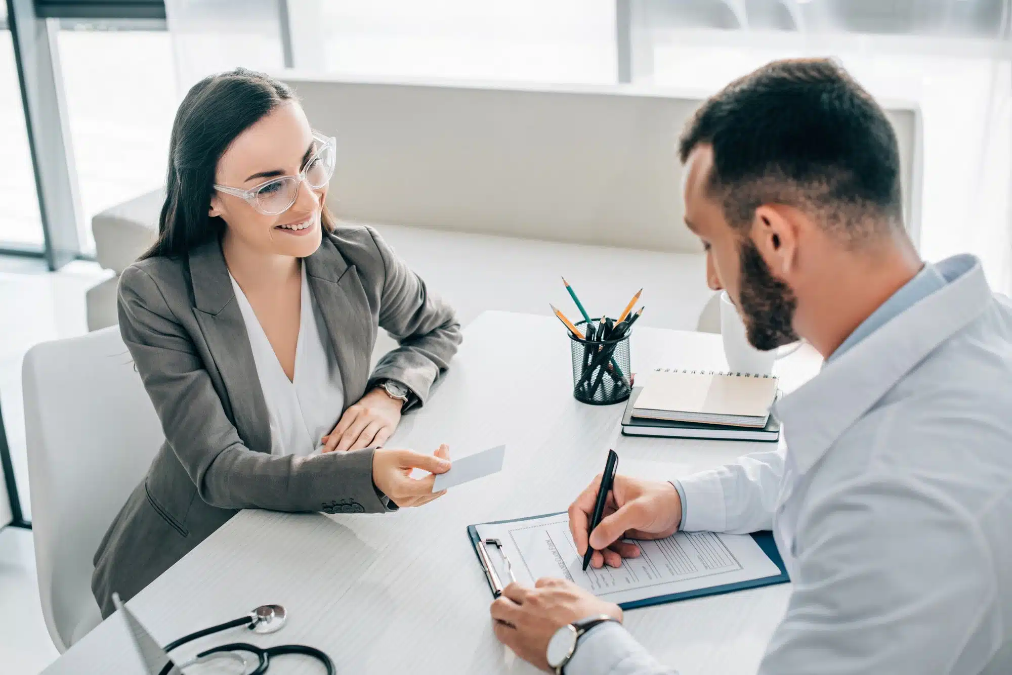 woman providing insurance card to healthcare office