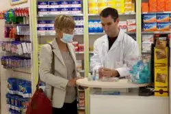 Woman looking at hand sanitizers regarding Canada's competition bureau cracking down on price gouging