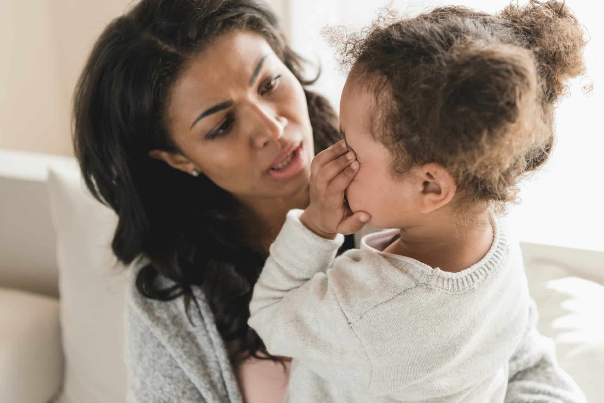 Mom comforts toddler girl