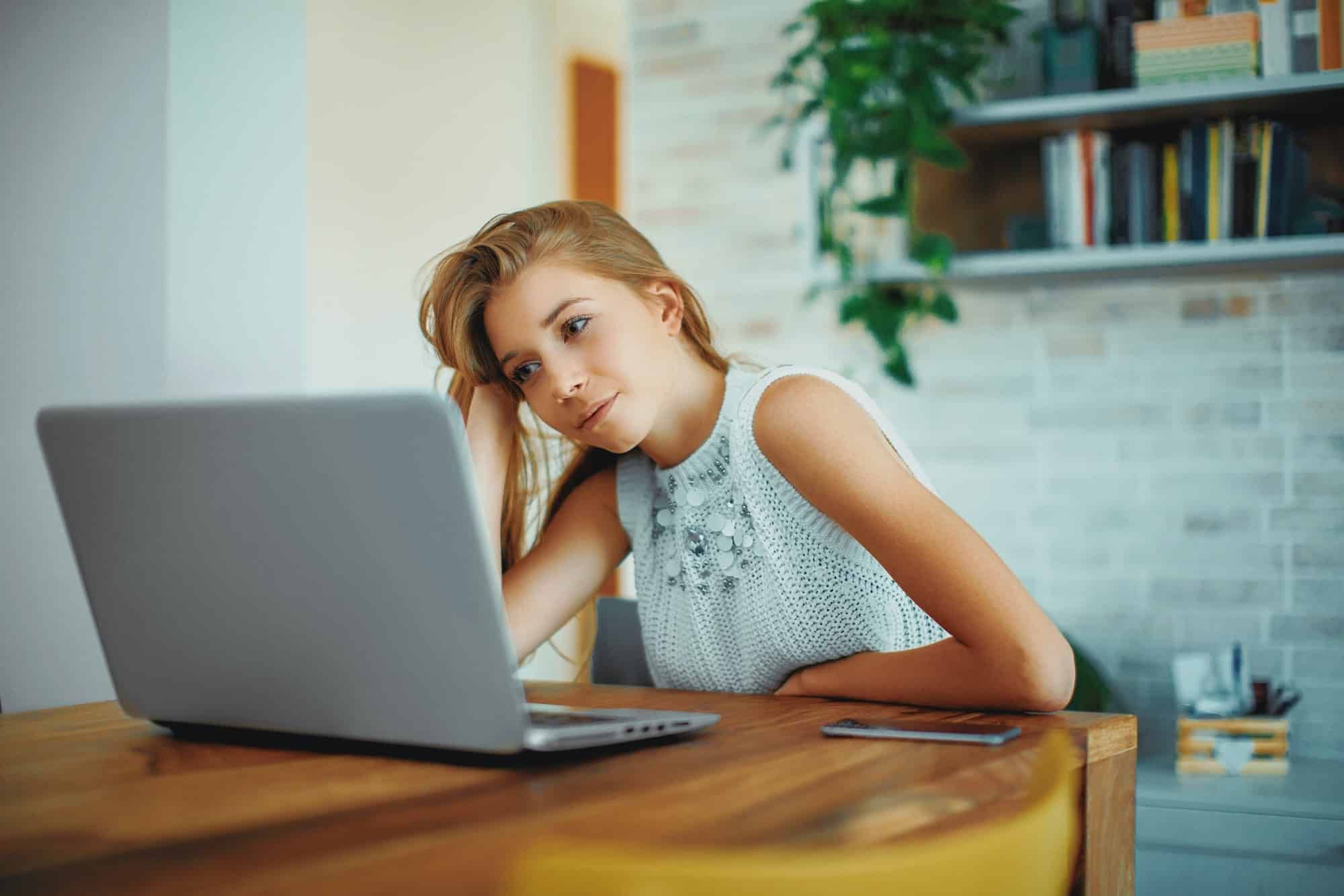 Stressed female student looks at laptop