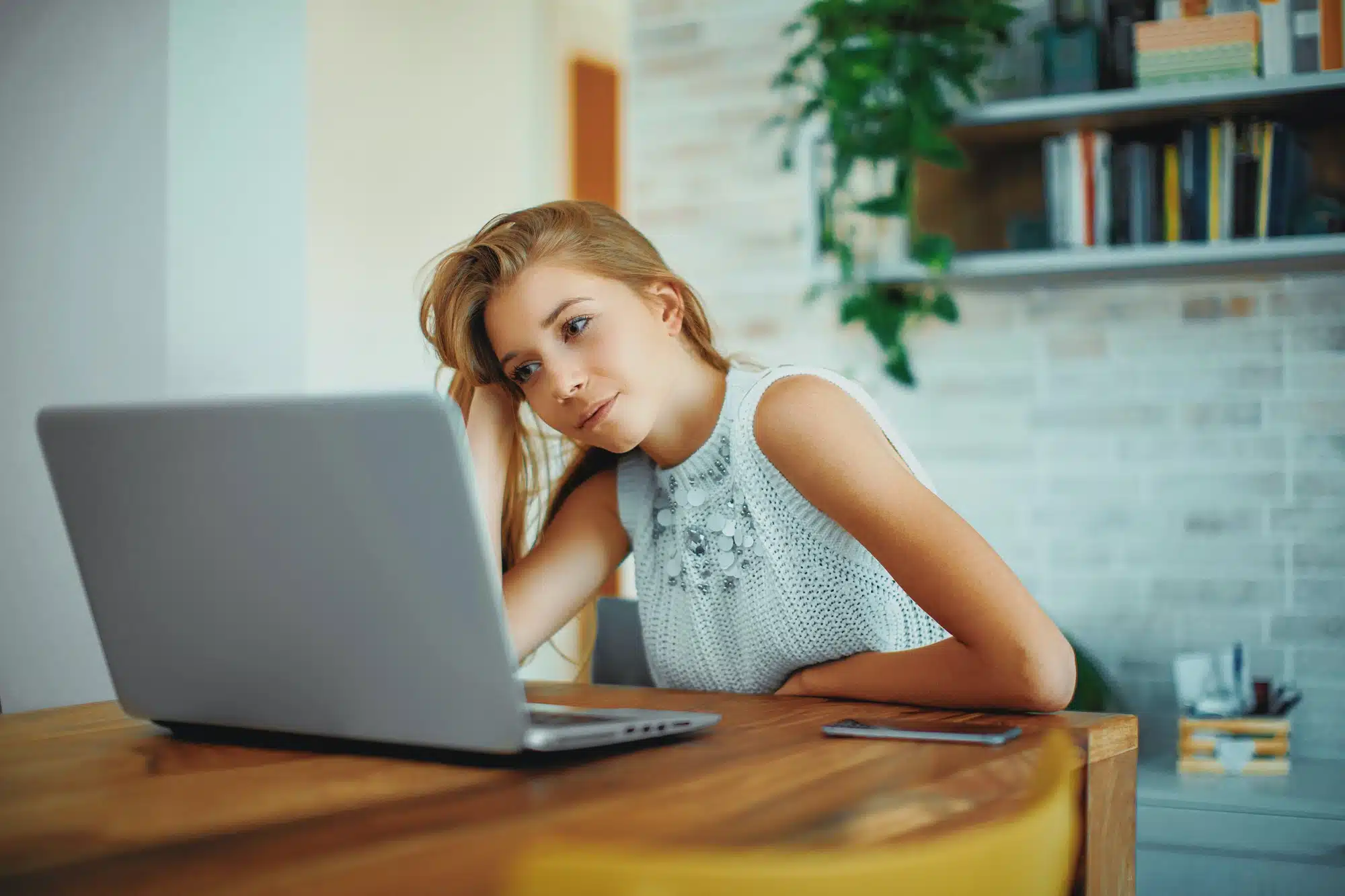 Stressed female student looks at laptop