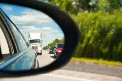 car seeing truck in rear view mirror