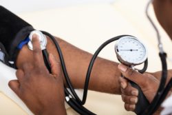 Close up of doctor taking blood pressure on patient's arm