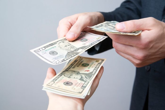 money exchanging hands to pay for COVID-19 face masks