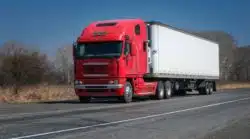 Red semi truck going down the road