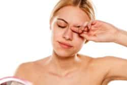 young woman rubbing eye