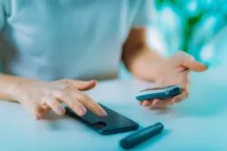 Closeup of woman's hands using blood sugar measuring devices