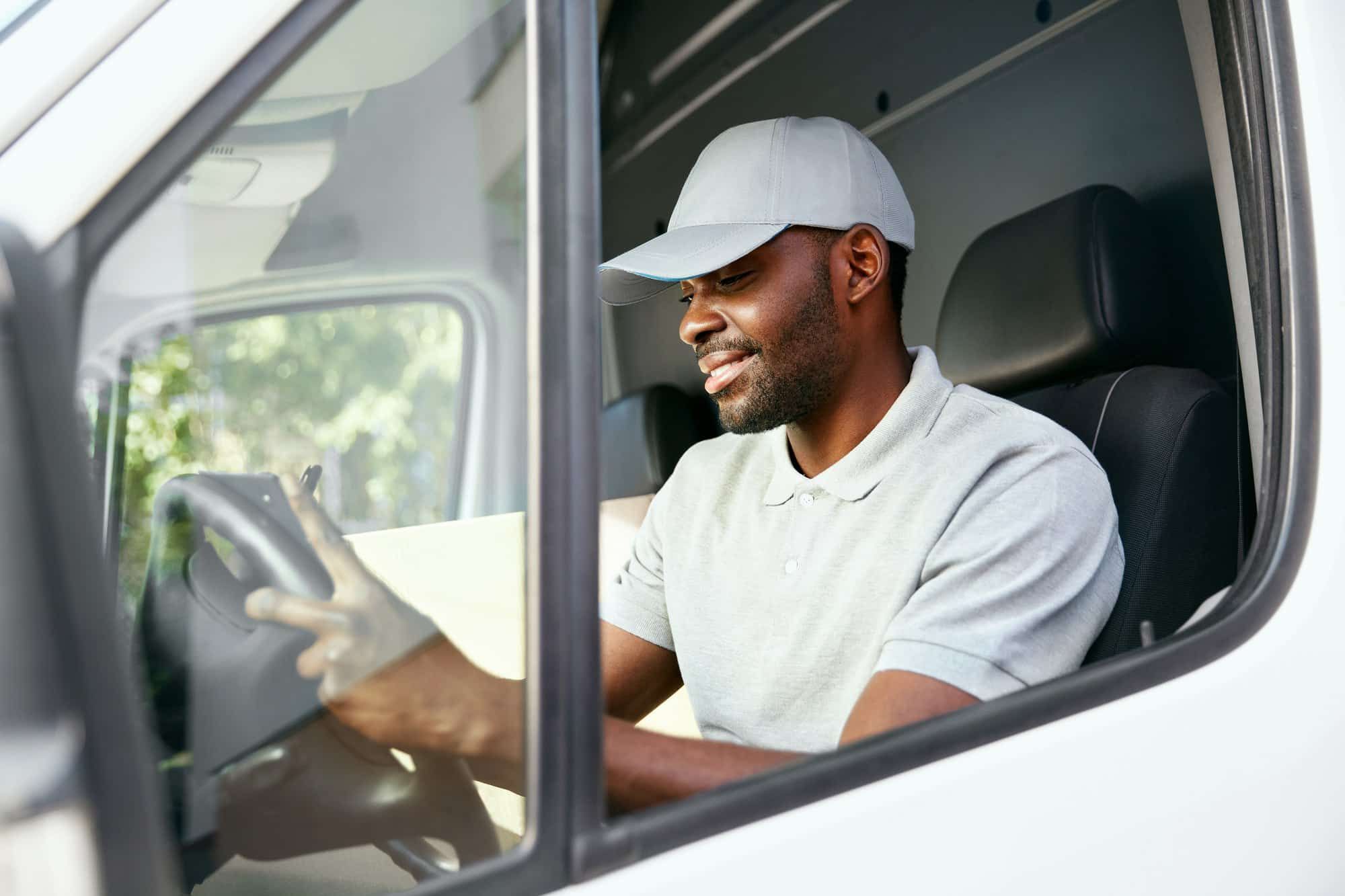 Truck driver checks address while in cab of truck