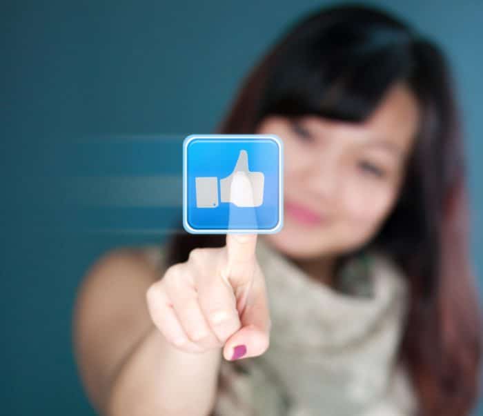 woman clicking "like" on Facebook app